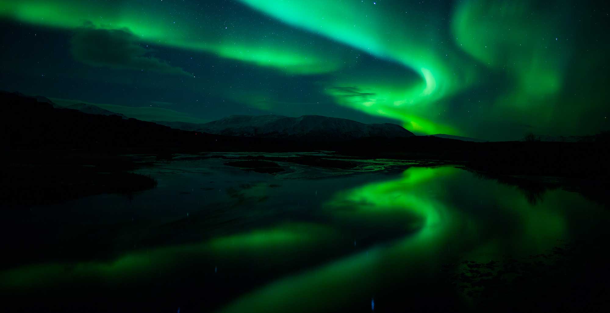 Image of the Aurora Borealis over snow-covered landscape.